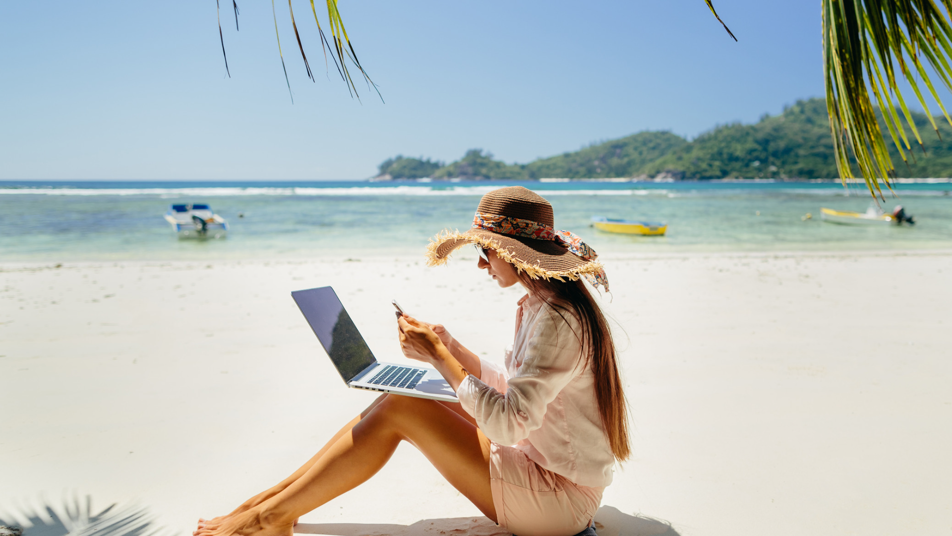 Lady working on DWA on a laptop at the beach